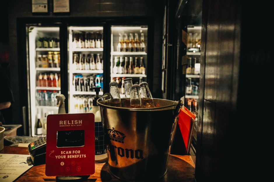 Een moderne barkoelkast in een horecagelegenheid, gevuld met dranken en ingrediënten voor de bar.